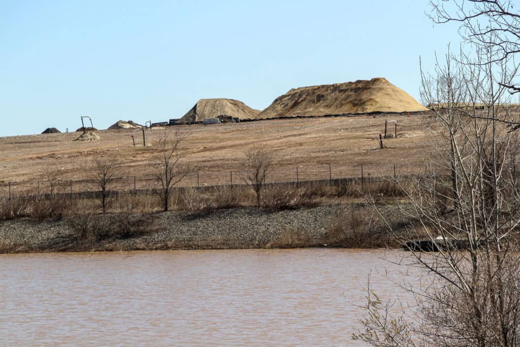 View of the West Mound with piles of sand across the water.